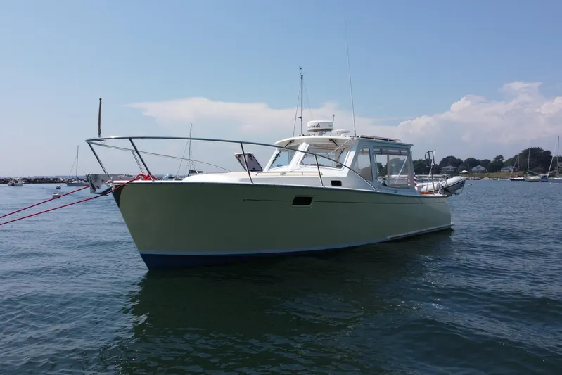 Tango Yacht Photos Pics 2006 MJM 34z Downeast boat anchored on calm water under a clear sky.
