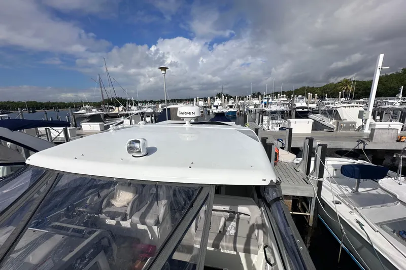  Yacht Photos Pics 2024 Beneteau Flyer 10 docked at a marina under a cloudy sky.