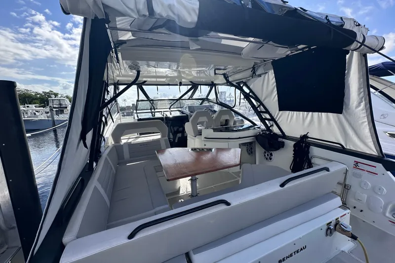  Yacht Photos Pics 2024 Beneteau Flyer 10 boat interior with seating and table, docked under clear skies.