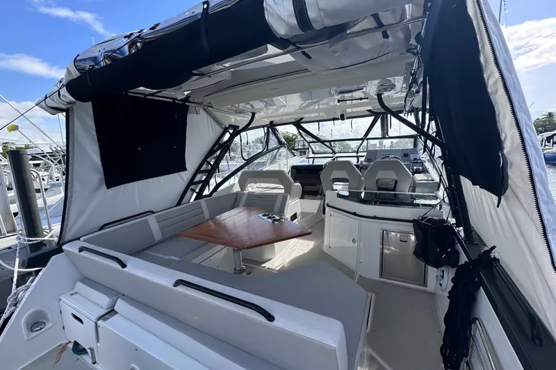  Yacht Photos Pics 2024 Beneteau Flyer 10 interior with seating, table, and helm, docked at marina.