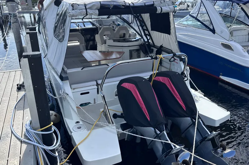  Yacht Photos Pics 2024 Beneteau Flyer 10 docked, featuring dual outboard motors and covered seating area.