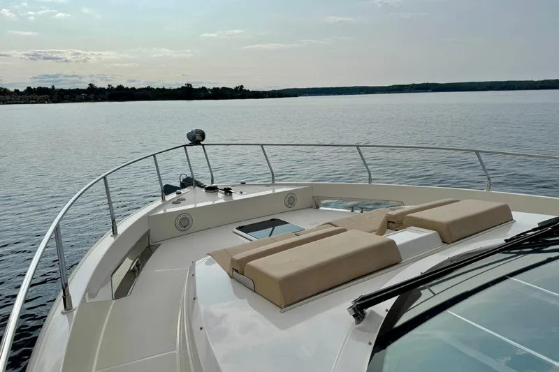 Orion Yacht Photos Pics 2018 Carver C52 Coupe yacht on calm water, featuring spacious deck and luxurious seating.
