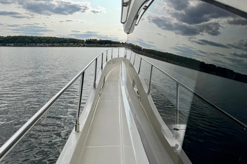 Orion Yacht Photos Pics 2018 Carver C52 Coupe yacht deck with scenic water view and cloudy sky.