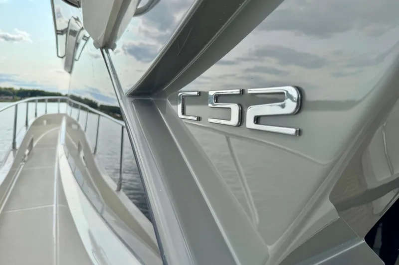 Orion Yacht Photos Pics 2018 Carver C52 Coupe yacht on water, showcasing sleek design and logo.