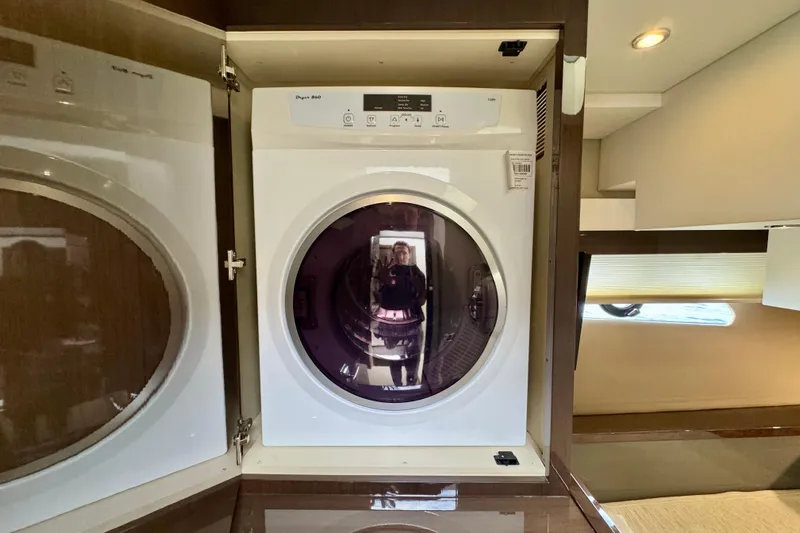 Orion Yacht Photos Pics Laundry area inside 2018 Carver C52 Coupe yacht with modern dryer.