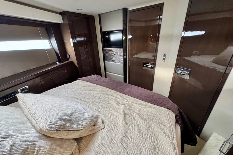 Orion Yacht Photos Pics Luxurious interior of 2018 Carver C52 Coupe yacht bedroom with elegant wood finishes.