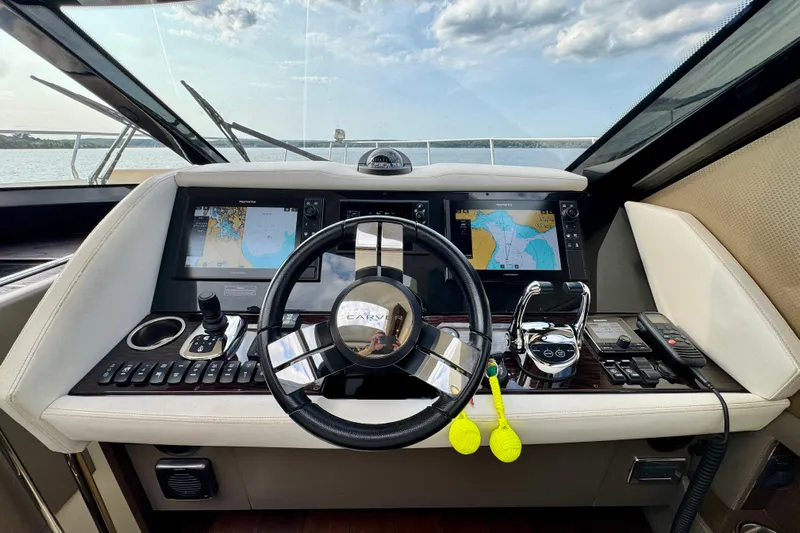Orion Yacht Photos Pics Carver C52 Coupe 2018 yacht helm with navigation screens and controls on a sunny day.