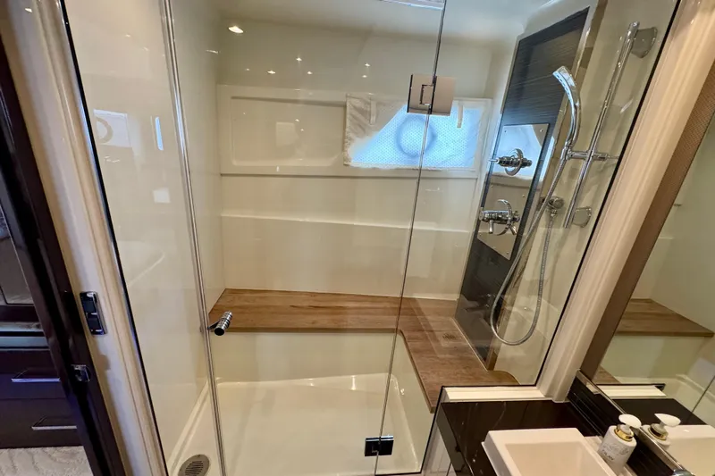 Orion Yacht Photos Pics Luxurious shower in 2018 Carver C52 Coupe with glass door and wooden bench.