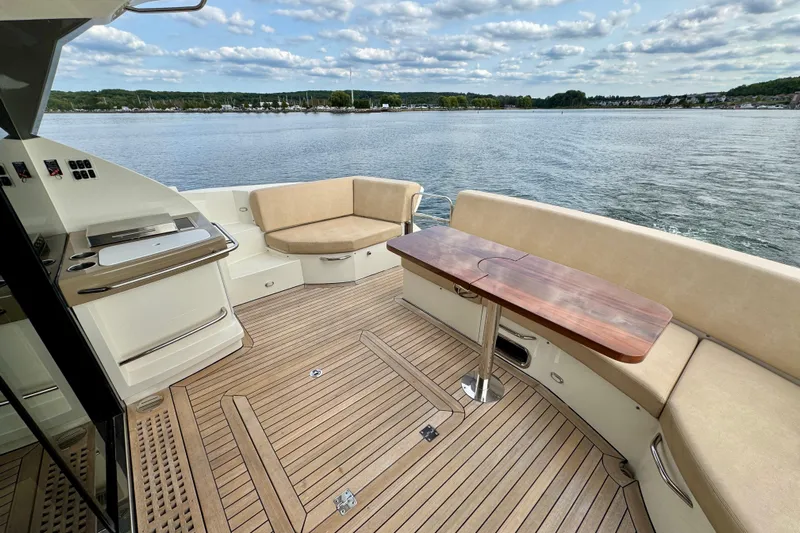Orion Yacht Photos Pics 2018 Carver C52 Coupe yacht deck with seating and table, overlooking serene water.