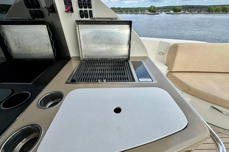 Orion Yacht Photos Pics Outdoor grill and seating area on 2018 Carver C52 Coupe yacht, overlooking serene waters.