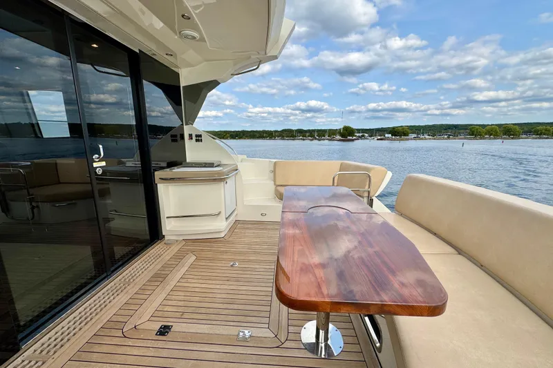 Orion Yacht Photos Pics Luxurious 2018 Carver C52 Coupe yacht deck with wooden table and scenic water view.