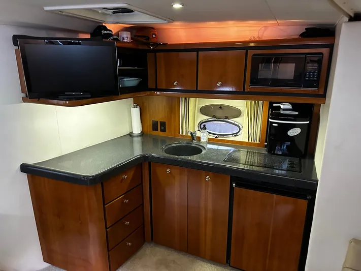  Yacht Photos Pics 2000 Carver 400 Express yacht kitchen with wood cabinets, microwave, and TV.