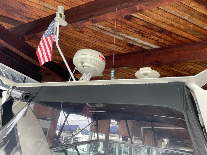  Yacht Photos Pics 2000 Carver 400 Express boat under wooden roof with American flag and radar equipment.