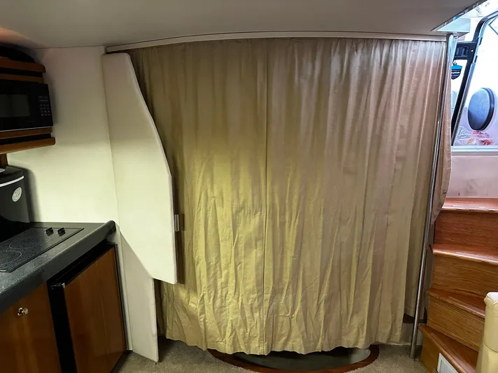  Yacht Photos Pics Interior of a 2000 Carver 400 Express yacht with curtain, kitchenette, and stairs.