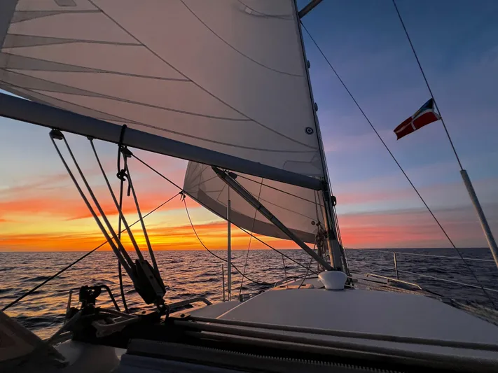 Monlove Yacht Photos Pics Sailing on a 2007 Beneteau Oceanis Clipper 393 at sunset, vibrant sky, open sea.