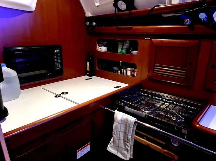 Monlove Yacht Photos Pics Galley of 2007 Beneteau Oceanis Clipper 393 with stove, microwave, and storage shelves.