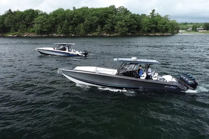  Yacht Photos Pics 2022 Nor-Tech 390 Sport boats cruising on a scenic lake with lush green shoreline.