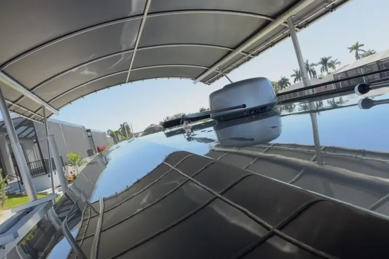  Yacht Photos Pics 2022 Nor-Tech 390 Sport boat under a canopy, reflecting clear blue sky and palm trees.