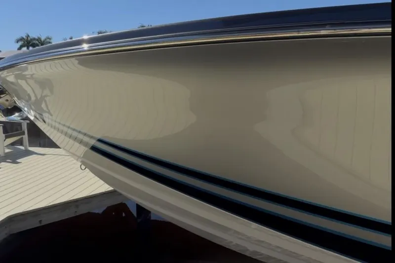  Yacht Photos Pics 2022 Nor-Tech 390 Sport boat hull reflecting sunlight at a dock.