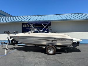2001 Larson SEi 190 boat on trailer, parked outdoors under clear blue sky.
