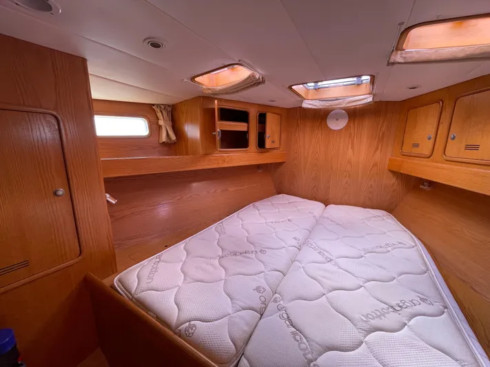 Chandelle Yacht Photos Pics Cozy cabin interior of 2008 Alubat OVNI 435 sailboat with wooden finish and mattress.