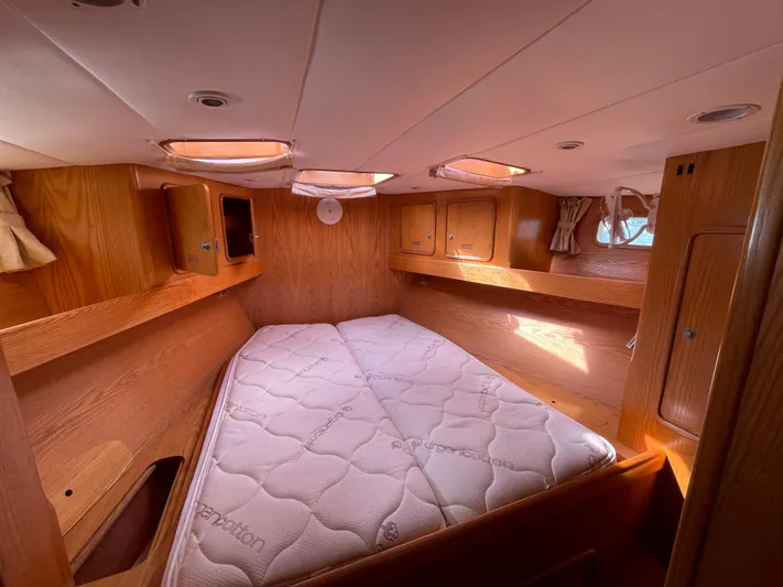 Chandelle Yacht Photos Pics Cozy cabin interior of 2008 Alubat OVNI 435 sailboat with wooden finish and mattress.