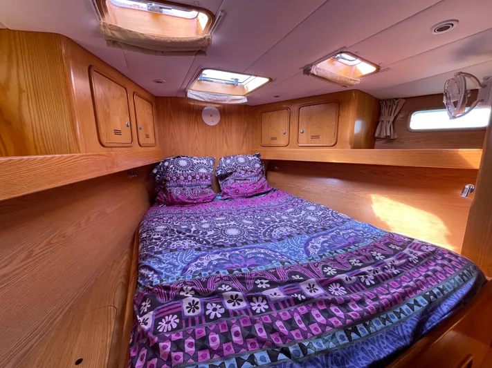 Chandelle Yacht Photos Pics Cozy cabin interior of 2008 Alubat OVNI 435 sailboat with colorful bedding and wooden finish.