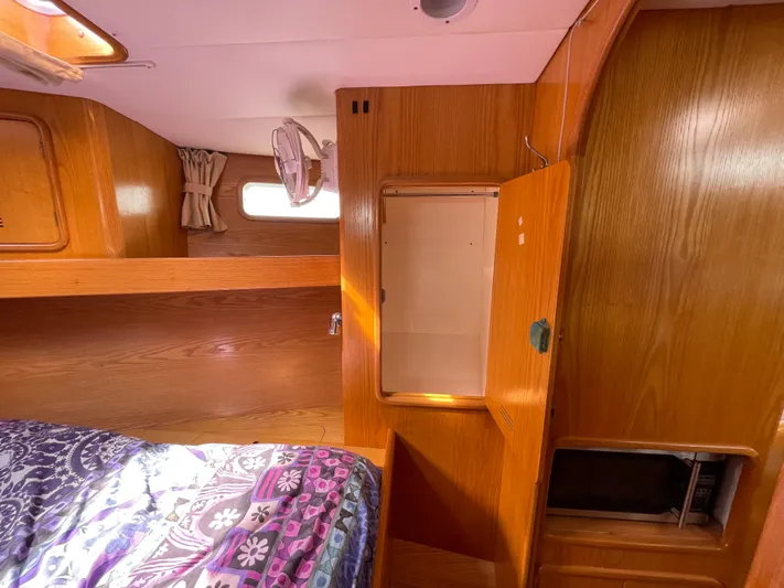Chandelle Yacht Photos Pics Cozy cabin interior of 2008 Alubat OVNI 435 sailboat with wood paneling and bed.