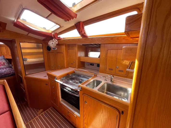 Chandelle Yacht Photos Pics 2008 Alubat OVNI 435 yacht kitchen with wood cabinetry, dual sinks, and oven.