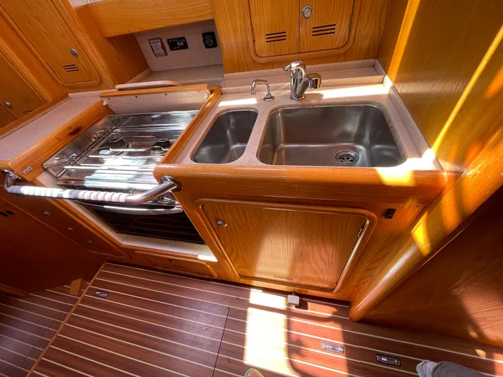 Chandelle Yacht Photos Pics 2008 Alubat OVNI 435 yacht kitchen with wooden cabinetry, dual sink, and stove.