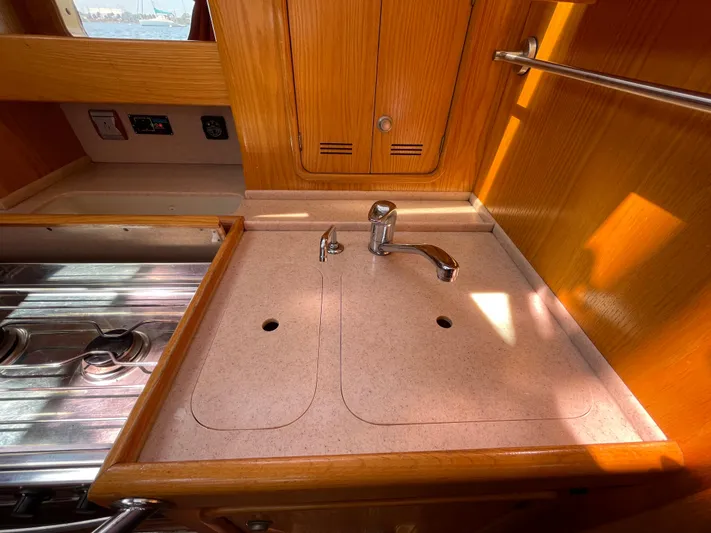 Chandelle Yacht Photos Pics 2008 Alubat OVNI 435 yacht kitchen sink with wooden cabinetry and stainless steel stove.