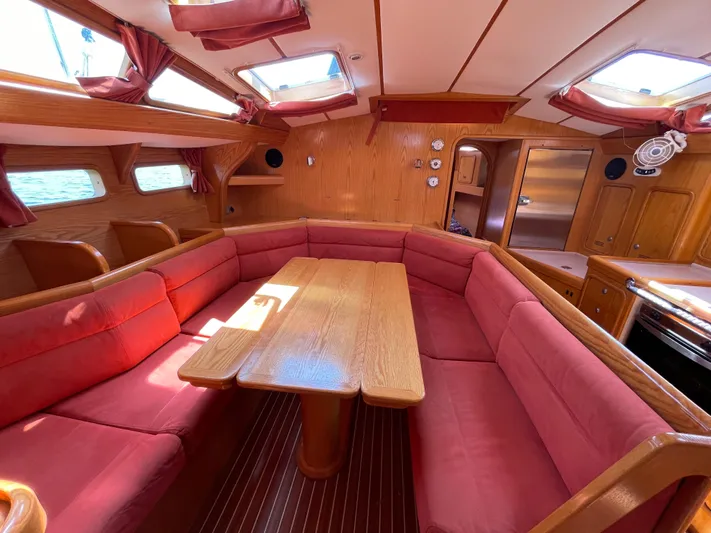 Chandelle Yacht Photos Pics Spacious interior of 2008 Alubat OVNI 435 yacht with red seating and wooden table.