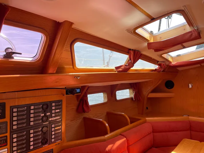 Chandelle Yacht Photos Pics Interior of 2008 Alubat OVNI 435 yacht with wood paneling and red seating.