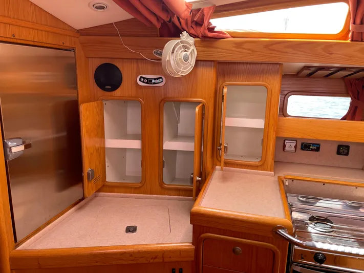 Chandelle Yacht Photos Pics Interior of 2008 Alubat OVNI 435 yacht kitchen with wooden cabinets and stainless steel appliances.