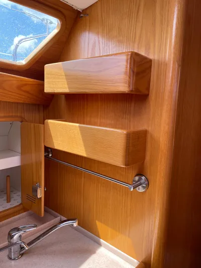 Chandelle Yacht Photos Pics Wooden interior of 2008 Alubat OVNI 435 yacht with shelves and faucet.
