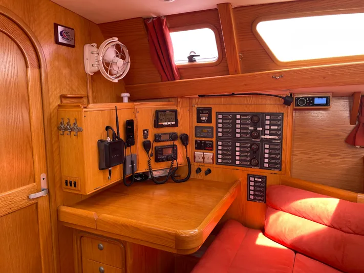 Chandelle Yacht Photos Pics Navigation station in 2008 Alubat OVNI 435 yacht with control panels and red seating.