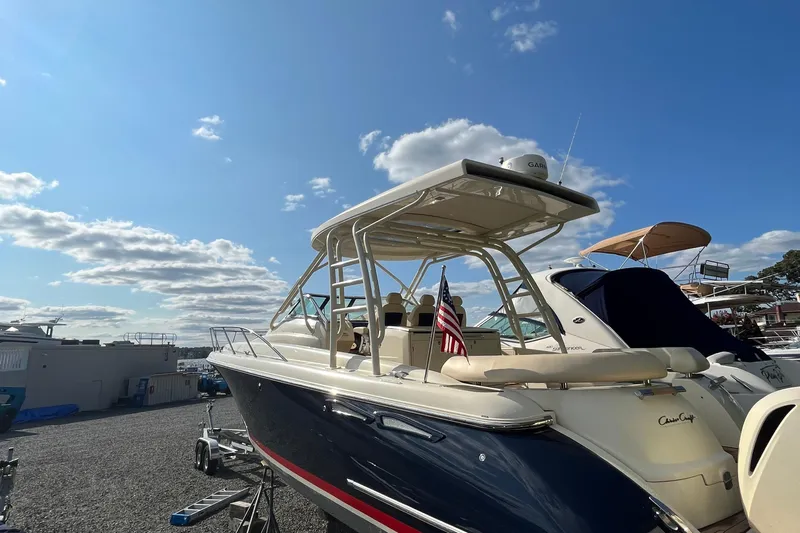  Yacht Photos Pics 2016 Chris-Craft Launch 36 boat with American flag, parked under a clear blue sky.