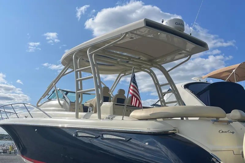  Yacht Photos Pics 2016 Chris-Craft Launch 36 boat with American flag, docked under a clear blue sky.