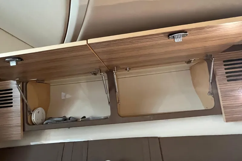  Yacht Photos Pics 2016 Chris-Craft Launch 36 interior cabinet with open wooden doors and storage space.