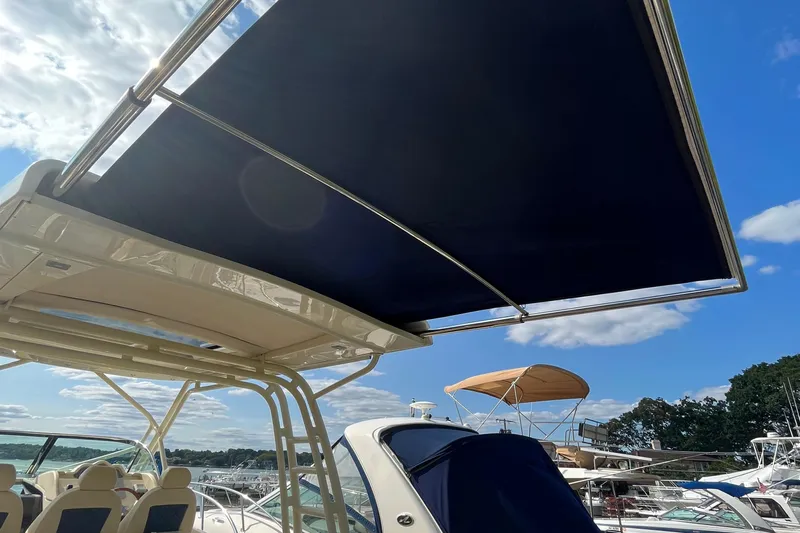  Yacht Photos Pics 2016 Chris-Craft Launch 36 boat with sunshade, docked under a clear blue sky.