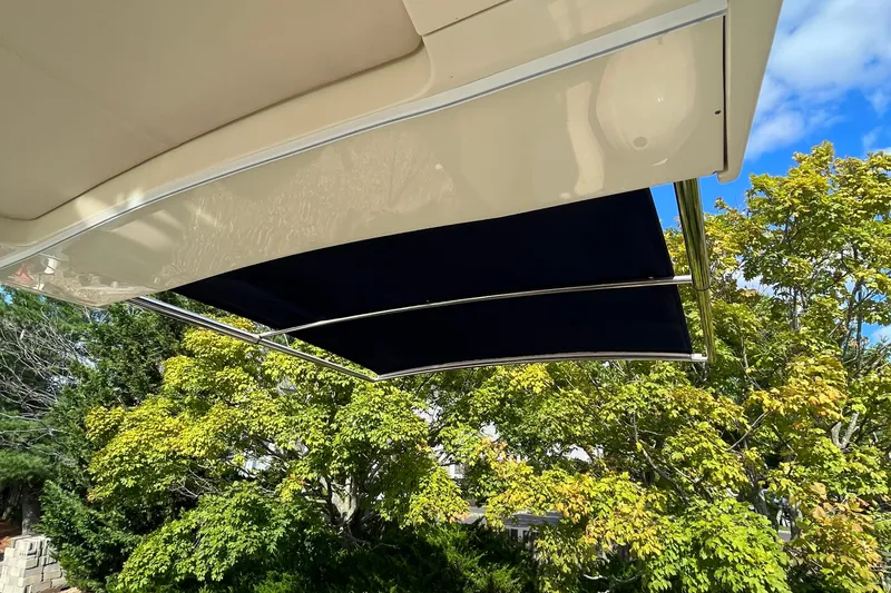  Yacht Photos Pics 2016 Chris-Craft Launch 36 boat canopy against a backdrop of green trees and blue sky.