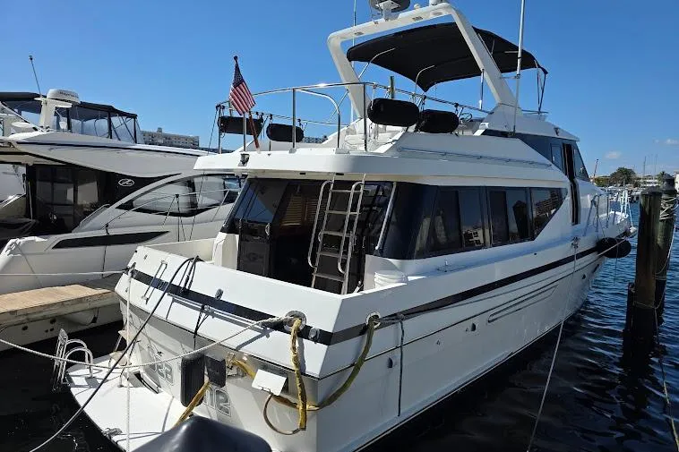 Yacht Photos Pics 1993 McKinna 48 Pilothouse yacht docked at marina, featuring sleek design and American flag.