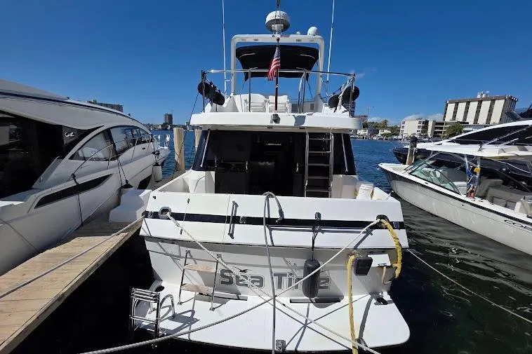  Yacht Photos Pics 1993 McKinna 48 Pilothouse yacht docked at marina, rear view with clear blue sky.