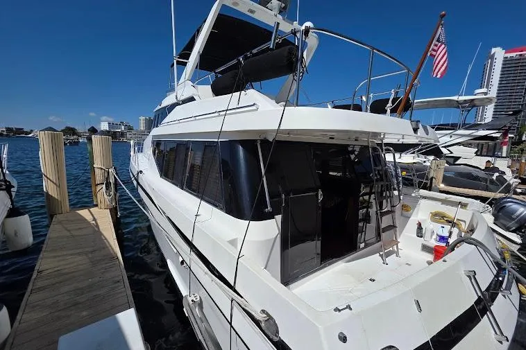  Yacht Photos Pics 1993 McKinna 48 Pilothouse yacht docked at marina with American flag.