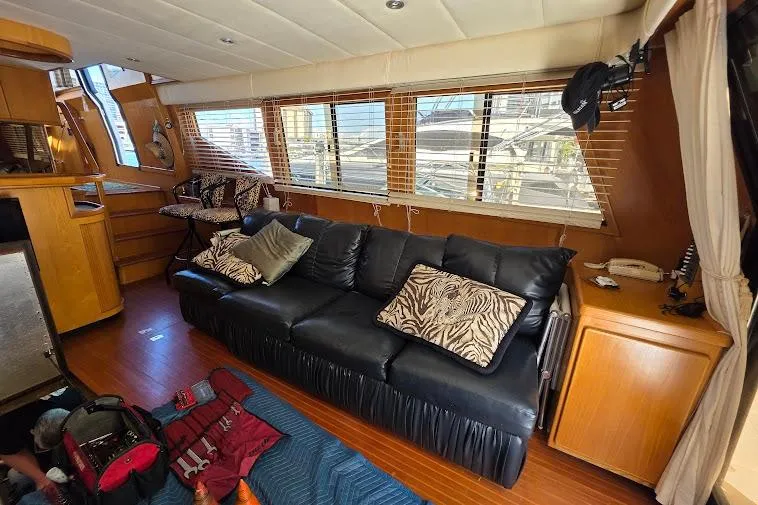  Yacht Photos Pics Interior of 1993 McKinna 48 Pilothouse with black leather sofa and wooden accents.