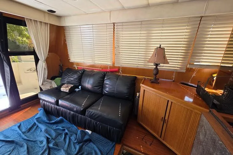  Yacht Photos Pics Interior of 1993 McKinna 48 Pilothouse with leather sofa, wooden cabinets, and blinds.