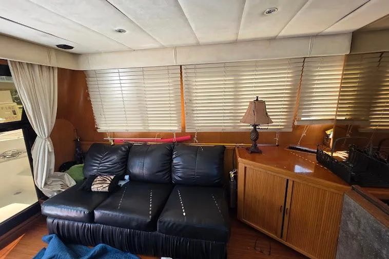  Yacht Photos Pics Interior of 1993 McKinna 48 Pilothouse with black leather sofa and wooden cabinetry.