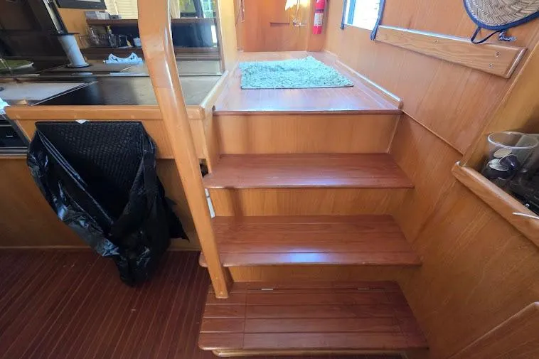  Yacht Photos Pics Interior stairs of 1993 McKinna 48 Pilothouse yacht with wooden finish.