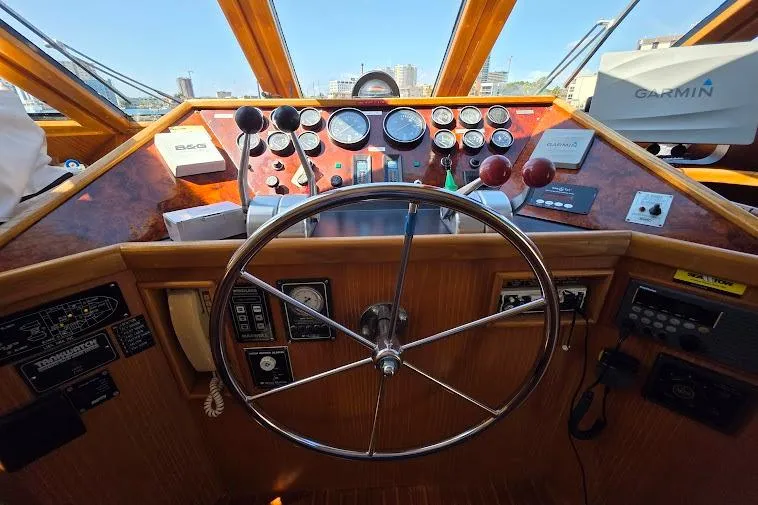  Yacht Photos Pics 1993 McKinna 48 Pilothouse helm with steering wheel, gauges, and navigation equipment.
