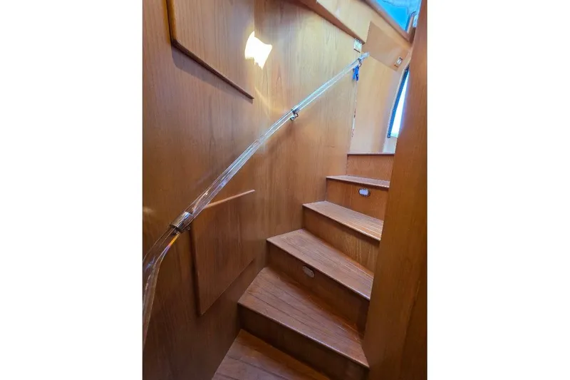  Yacht Photos Pics Wooden staircase inside 1993 McKinna 48 Pilothouse yacht, featuring sleek handrail design.